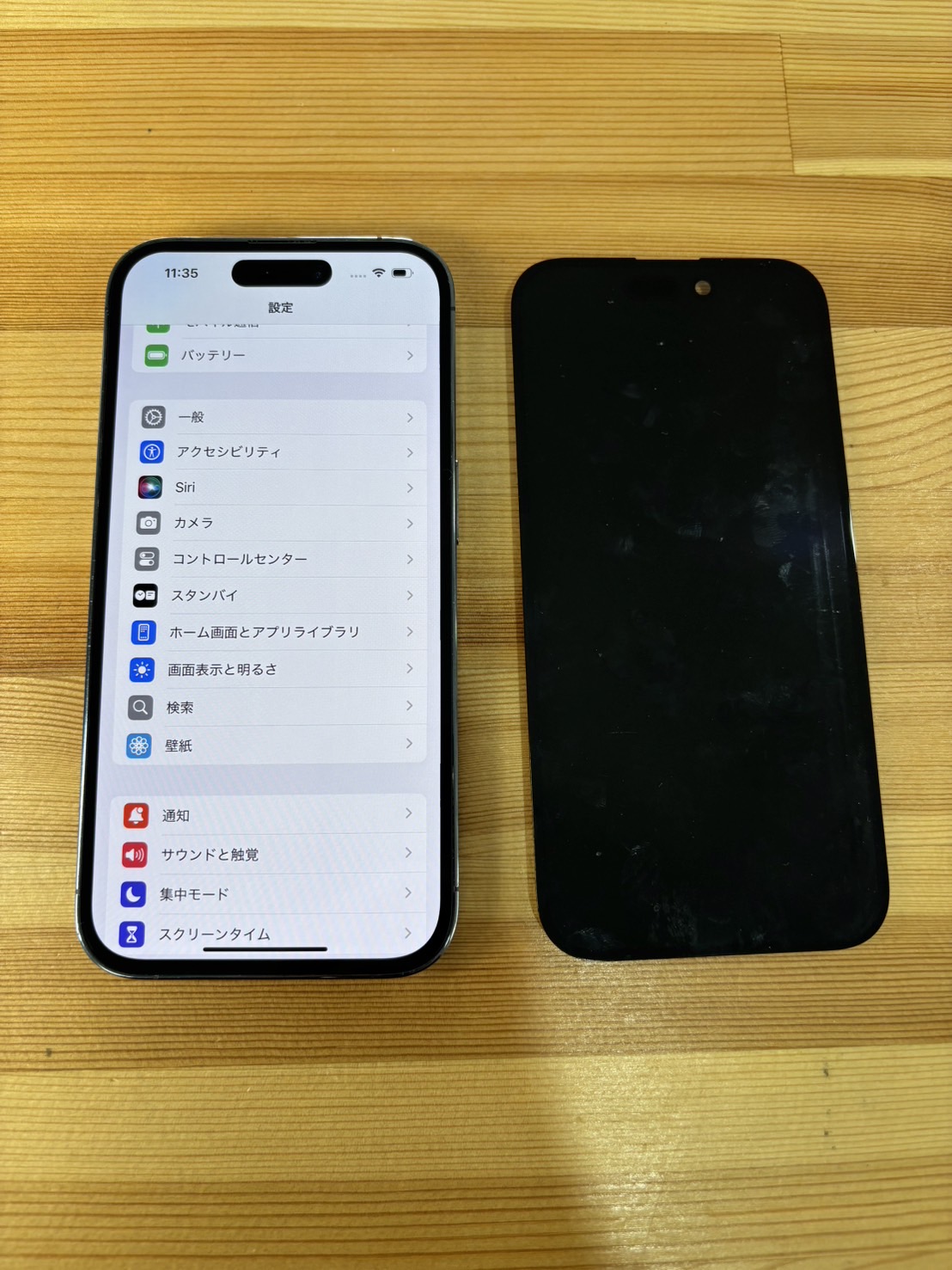交換した旧パネルと修理後のiPhone